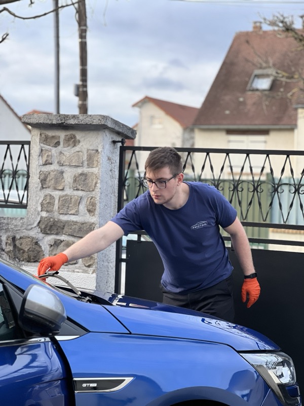 Un artisan SWDTAIL intervient sur un véhicule à domicile, devant le portail d'une maison en Essonne